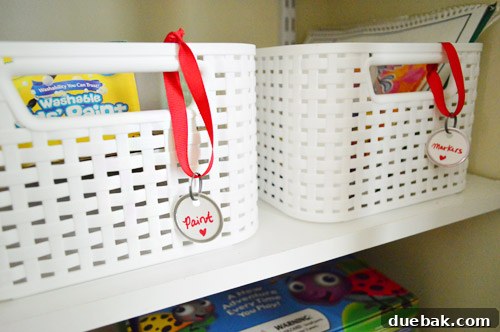 From Coat Closet To Toy Central 12 Neatly organized toy baskets, some with text labels, on the shelves of the toy library closet.