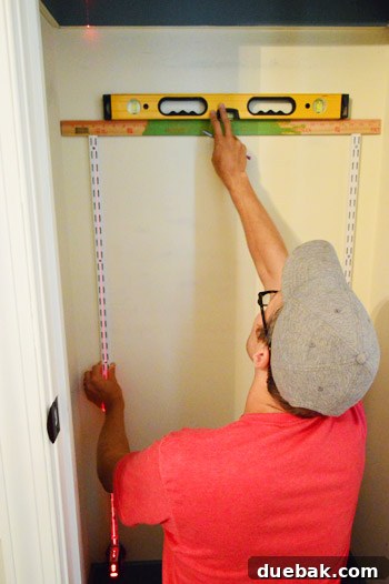 From Coat Closet To Toy Central 7 Measuring and leveling the second vertical track to ensure perfect alignment with the first.