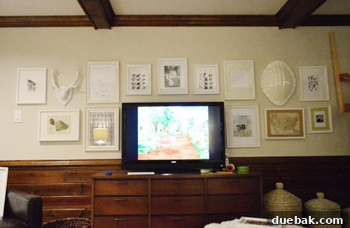 Gallery wall mostly complete, with a visible light switch issue