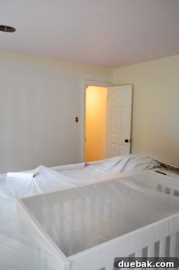 Close-up of a wall in Clara's room, showing primed sections next to the newly painted pink ceiling.
