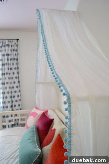 Child's perspective of a white fabric bed canopy hanging over a bed