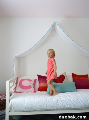 Clara looking up at her new bed canopy with delight