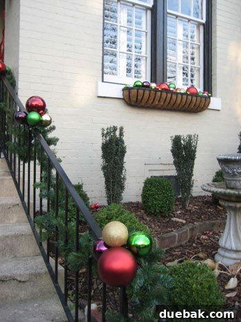 Ornaments in Window Baskets and Railings Oversized Christmas ornaments bound together along porch railings and placed in window baskets for extra sparkle.