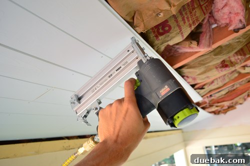 Applying wood glue to ceiling joist