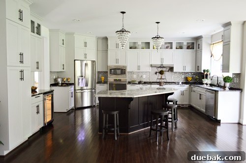 Grand kitchen with extensive cabinetry and an illuminated wine fridge