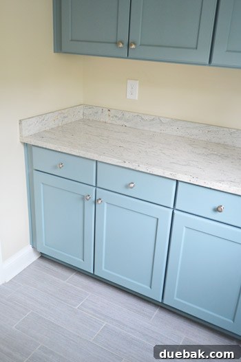 Unfinished mudroom showcasing stylish floor tile and powder blue cabinets