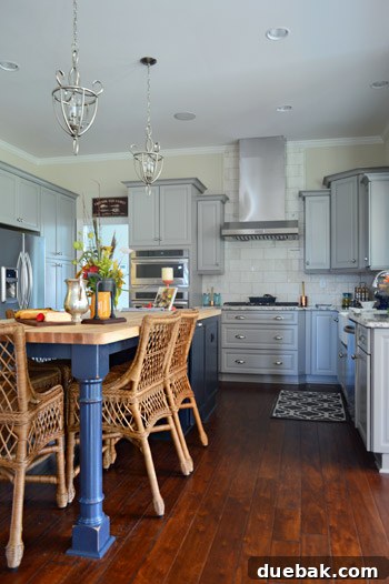 Modern kitchen with gray cabinets, accent island, and marble subway tile backsplash
