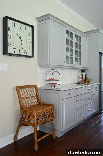 Close-up of glass-fronted kitchen cabinets with marble subway tile backsplash