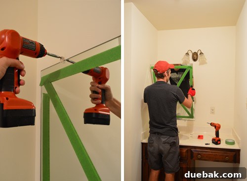 The old frameless mirror being carefully removed from the bathroom wall