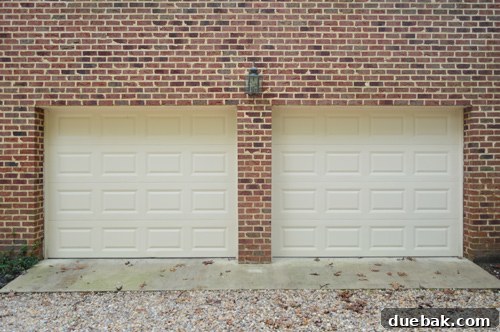 Old, small exterior light above garage doors