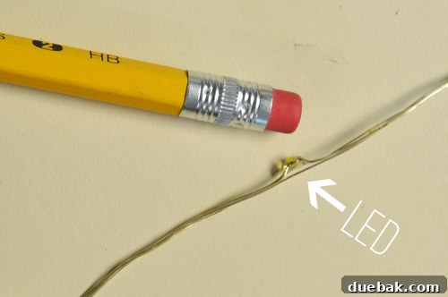 A string of fairy lights held in hand, emphasizing the thinness of the wire and the small size of the LEDs.