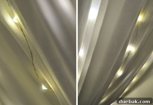 Clara's bed canopy with fairy lights glowing, creating a soft, warm ambiance in her bedroom.