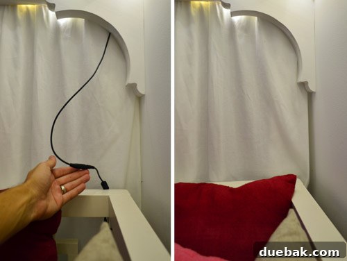 Close-up showing the power adapter for fairy lights hidden behind Clara's bed, with John's hand demonstrating.