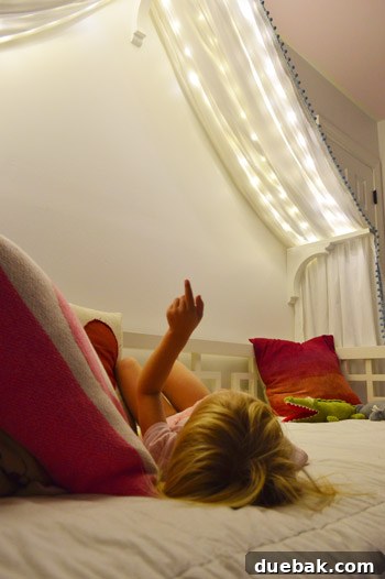 Clara's bedroom at night, illuminated by the gentle glow of fairy lights within her bed canopy, creating a magical scene.