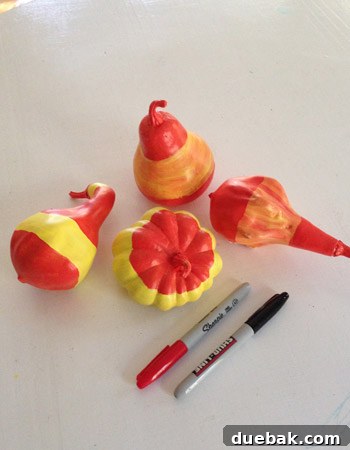 Pumpkins Transformed: The Pantyhose Touch 10 Multiple painted faux gourds, some solid yellow, others with a blended orange base, all featuring distinct red-orange decorative bands.