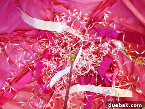 Close-up of the plastic curling ribbon being attached to the umbrella spines for the jellyfish costume tentacles.
