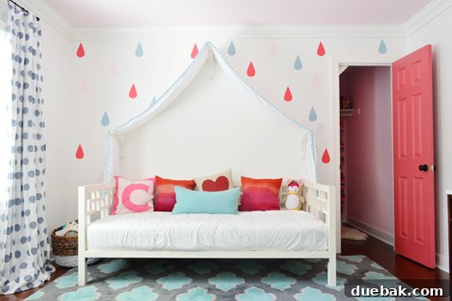 Girls Bedroom With Colorful Raindrop Mural Around Canopy Daybed With Closet Door Open - A view of the girl's bedroom featuring the colorful raindrop mural, canopy daybed, and the vibrant pink closet door standing open.