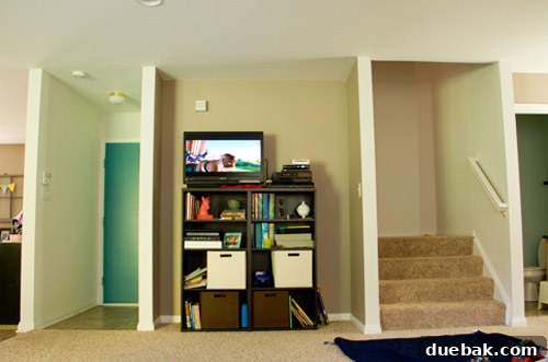 Open concept living room with awkward nook and garage door