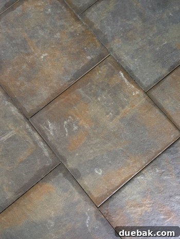 Close-up of stubborn dried thinset residue on the textured surface of an outdoor tile