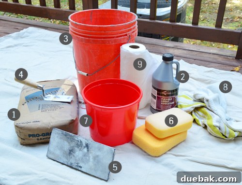 Grouting supplies laid out, including charcoal sanded grout, admixture, buckets, and sponges