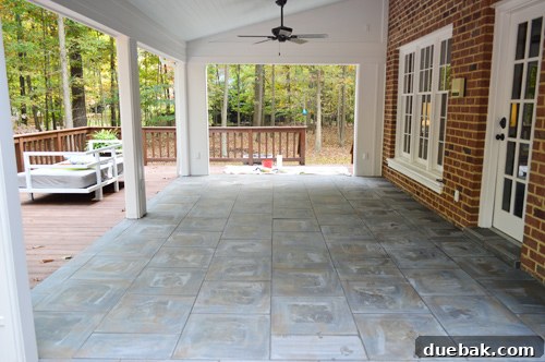 Outdoor tiled floor after initial grout cleaning, showing improved grout color and reduced haze