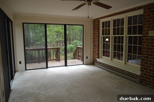 Before photo of the old sunroom floor, showing a stained and worn concrete surface