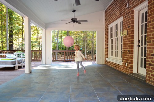 A child happily playing on the newly tiled outdoor floor, demonstrating its family-friendliness