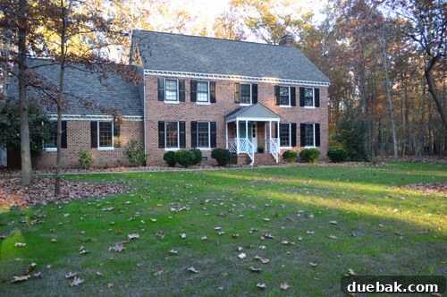 Our home's front yard before renovation, showing areas needing landscaping and tree removal.