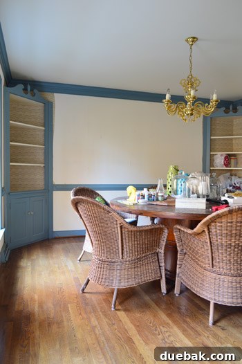 The dining room with blue trim, wallpaper, and built-ins, awaiting a complete aesthetic overhaul.