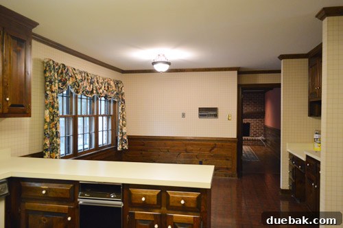Dark, traditional kitchen with wood paneling and trim before renovation