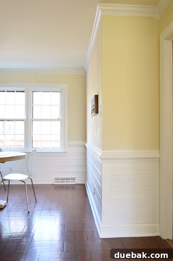 Joyful homeowner admiring the bright, newly painted white kitchen
