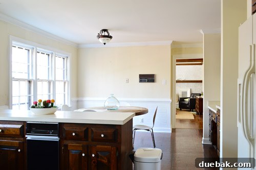 Bright, newly painted white kitchen after renovation with transformed wood paneling and trim