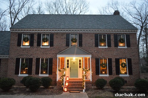 Effortless Window Wreath Styling 2 Our house exterior beautifully adorned with Home Alone-inspired Christmas decorations, featuring elegant wreaths on every window and glowing garland around the portico, creating a festive welcome.