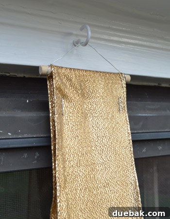 Effortless Window Wreath Styling 12 A Christmas wreath elegantly hanging on a downstairs window, with a subtle close-up highlighting the two small staples that securely hold the ribbon to the ingenious 'trapeze thing'.