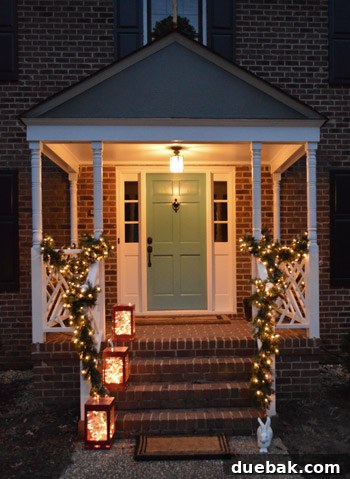 Effortless Window Wreath Styling 3 A close-up view of the gracefully draped lighted garland around the front portico railing, showcasing its warm, inviting glow and adding a touch of elegance to our Christmas porch decor.