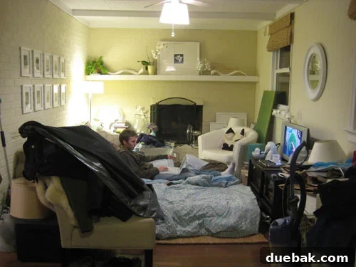 John Petersik working amidst renovation clutter in the den, surrounded by boxes and temporary furnishings.