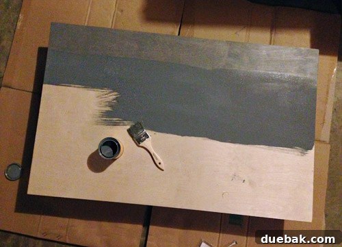 Get Crafting 4 DIY Holiday Decorations 4 Staining a piece of plywood gray with a brush to make a faux fireplace mantle