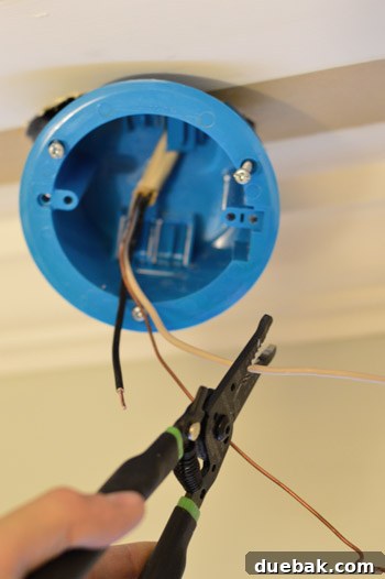Upgrade Your Lighting: Swapping Fluorescent Fixtures for Pendants 17 Stripping wires from old fluorescent light fixture while installing new old work box