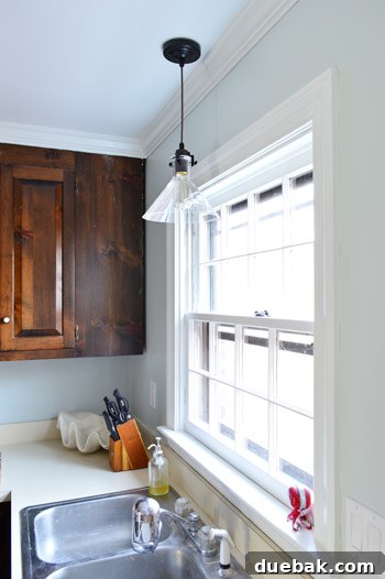Upgrade Your Lighting: Swapping Fluorescent Fixtures for Pendants 19 New glass pendant light over sink where fluorescent light used to be