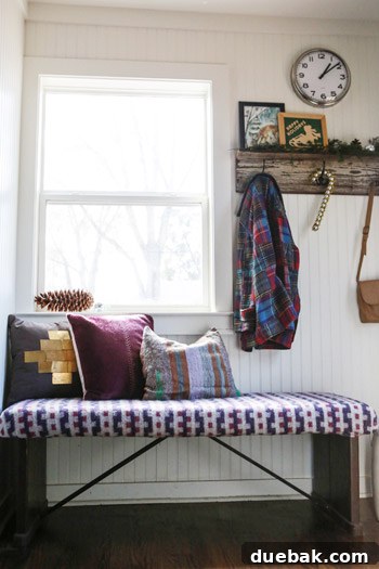 Mudroom area with rustic wood, a silver clock, and layered textiles, exuding coziness.