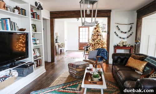Close-up of the living room's transformed area, showcasing the thrifted rug, coffee table, and repainted ottoman.