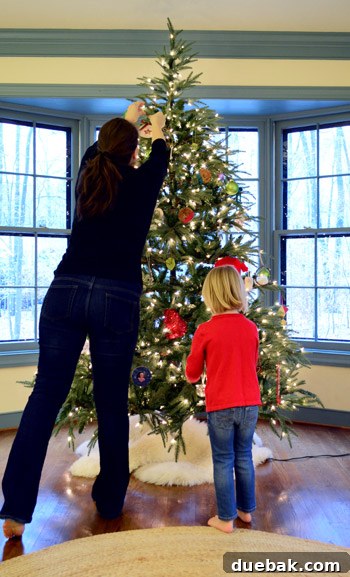 Rustic Wood Slice Christmas Creations 18 Mother and daughter decorating a large Christmas tree together