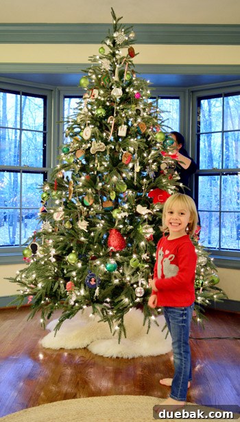 Rustic Wood Slice Christmas Creations 22 Child proudly posing next to a decorated Christmas tree
