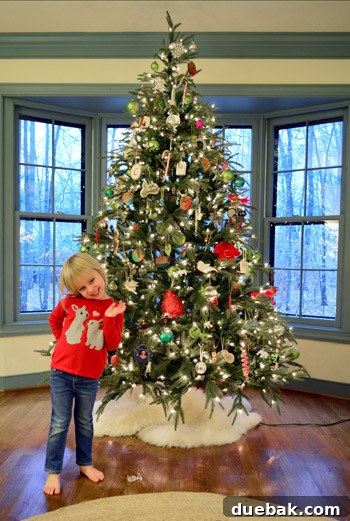 Rustic Wood Slice Christmas Creations 23 Happy child standing in front of a festive Christmas tree