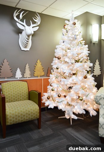 Brightening Little Lives: Our Holiday Hospital Makeover 4 White Christmas Tree With Gold Ornaments And Cardboard Safari Reindeer Head, creating a focal point in the welcoming hospital space.