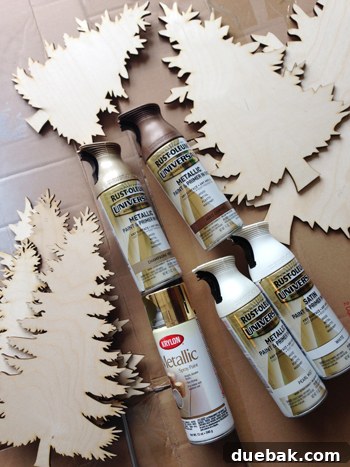 Brightening Little Lives: Our Holiday Hospital Makeover 7 Wood Christmas Pine Tree Cut Outs Before Painting With Cans Of Spray Paint, illustrating the creative stages of the wall decor.