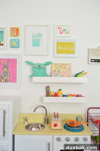 Clara's play wall from a slightly different angle, highlighting the practical use of shelves and interactive elements.