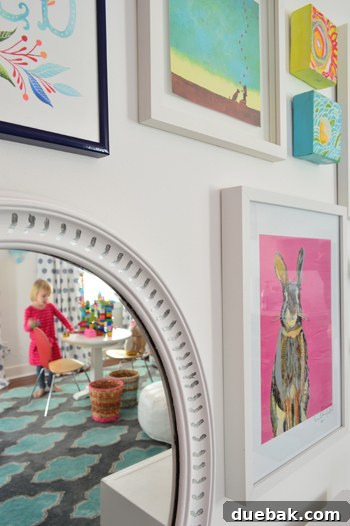 A beautifully decorated child's play wall featuring the newly hung, custom-painted mirror and colorful artwork.