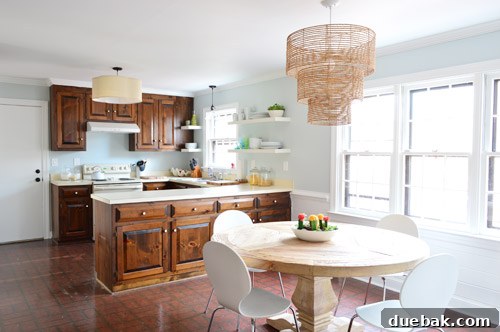 An updated 1980s kitchen showcasing newly added IKEA floating shelves and walls painted in a refreshing blue hue, marking significant progress in its renovation.
