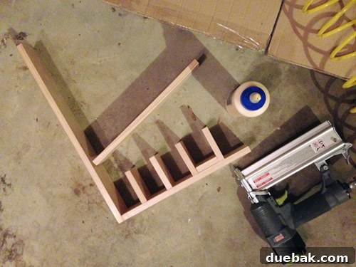 The first horizontal shelf and vertical dividers of the cubby being assembled with wood glue and brad nails.